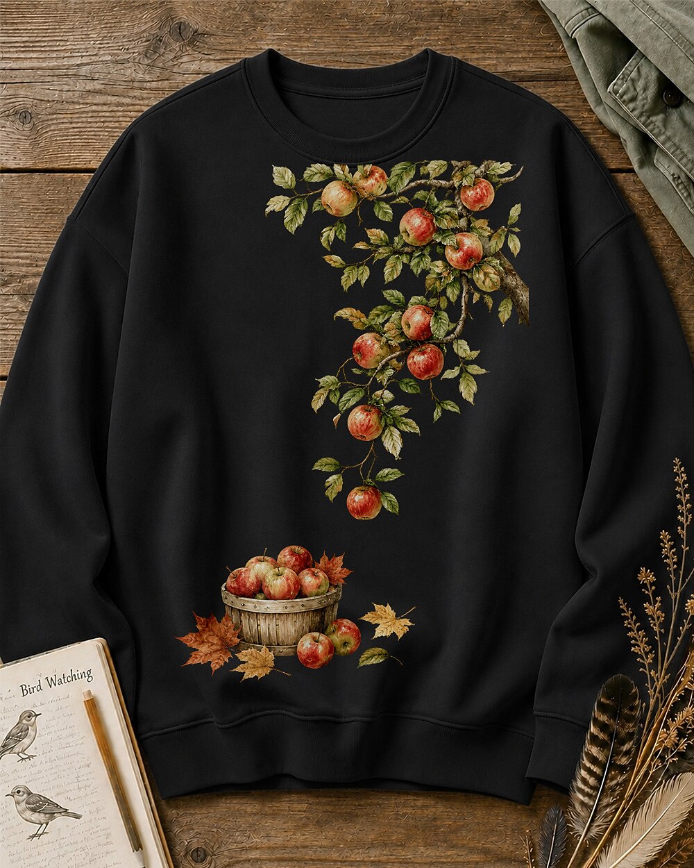 Women's black crewneck sweatshirt with apple branches and a harvest basket, front view.