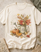 Women's off white cotton T-shirt with an autumn bouquet in a watering can with pumpkins, front view.