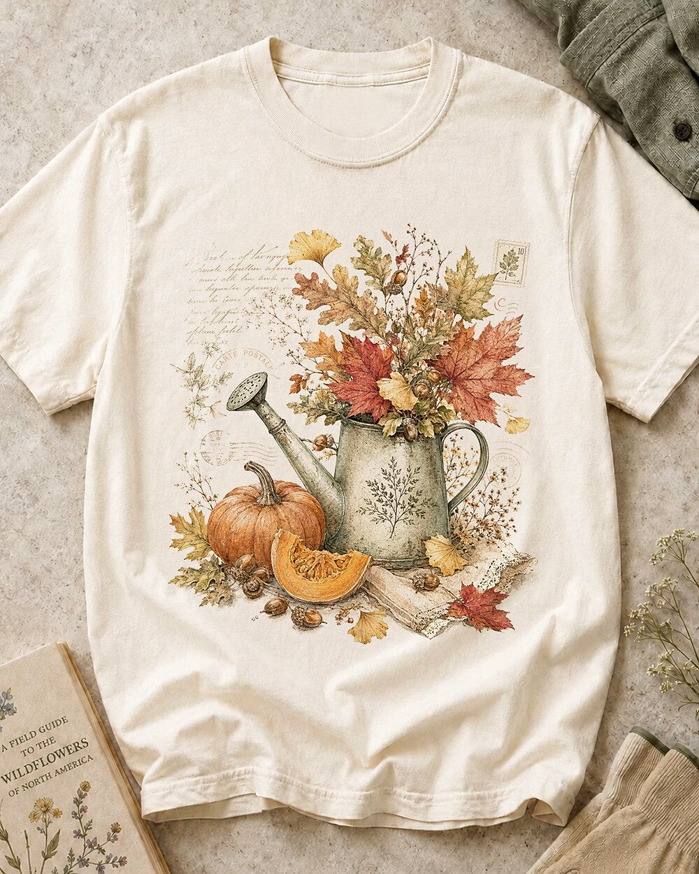 Women's off white cotton T-shirt with an autumn bouquet in a watering can with pumpkins, front view.