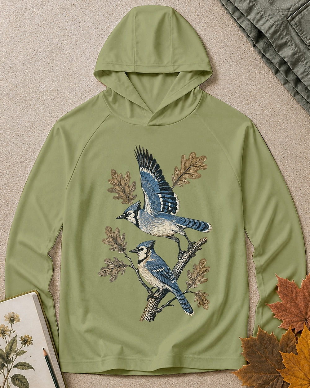Women's green sun hoodie with blue jays perched on oak branches, front view.