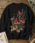 Women's black crewneck sweatshirt with cardinals among pink coneflowers, front view.