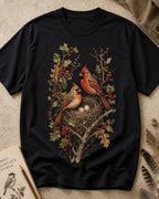 Women's black cotton T-shirt with a cardinal pair beside a nest, front view.