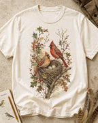 Women's off white cotton T-shirt with a cardinal pair beside a nest, front view.