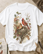 Women's white cotton T-shirt with a cardinal pair beside a nest, front view.