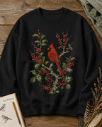 Women's black crewneck sweatshirt with a cardinal among red berry branches, front view.