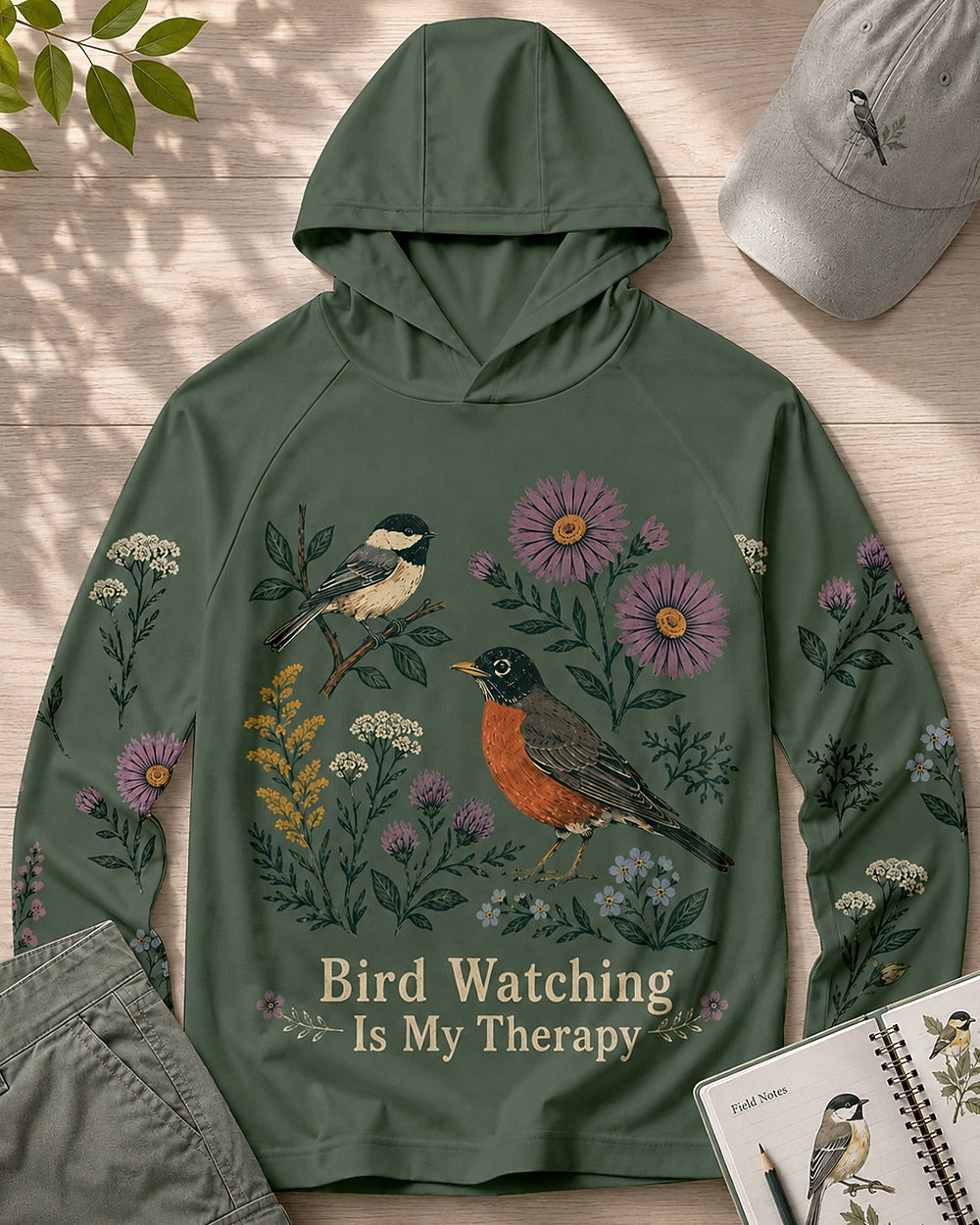 Women's green sun hoodie with a chickadee, robin and wildflowers, front view.