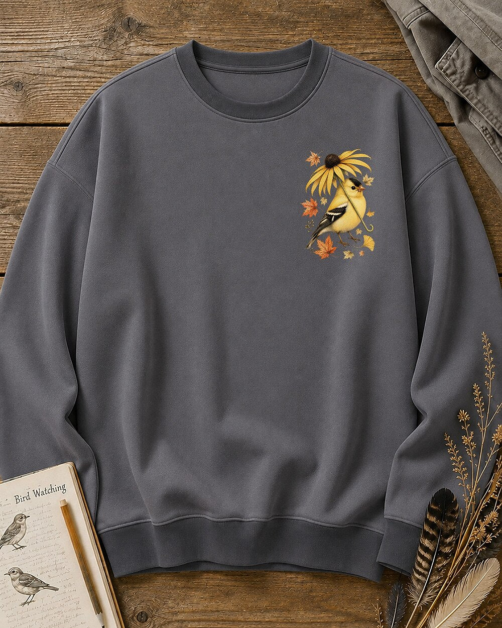 Women's gray crewneck sweatshirt with a small goldfinch and flower chest print, front view.