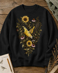 Women's black crewneck sweatshirt with goldfinches in flight among sunflowers, front view.