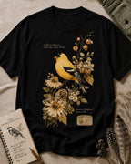Women's black cotton T-shirt with a goldfinch among yellow flowers, front view.