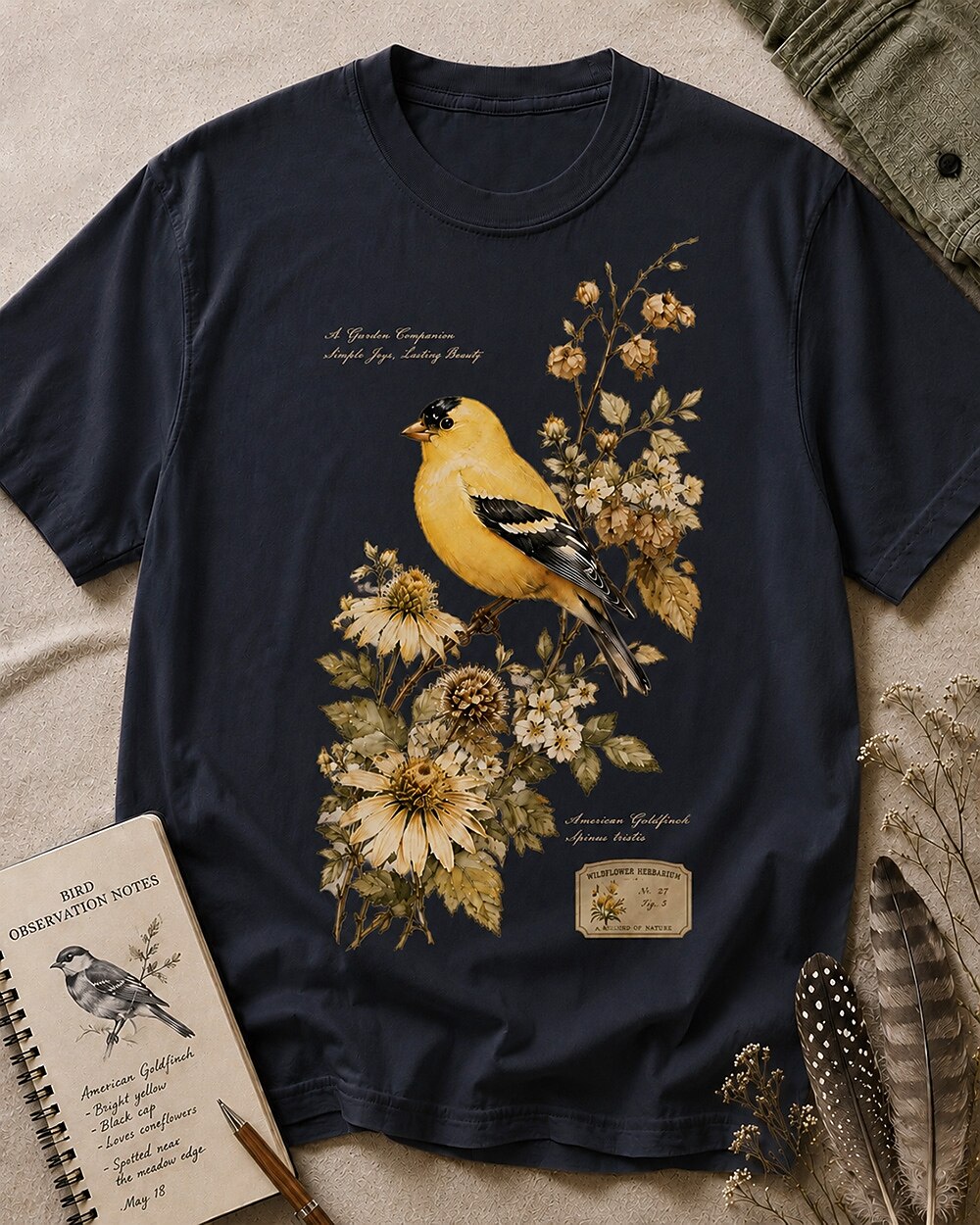 Women's dark navy cotton T-shirt with a goldfinch among yellow flowers, front view.