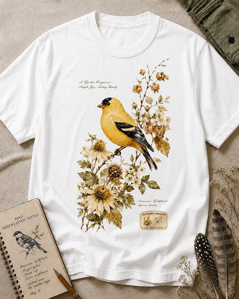 Women's white cotton T-shirt with a goldfinch among yellow flowers, front view.