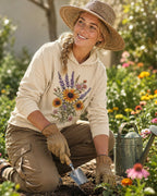 Woman wearing a light yellow sun hoodie with lavender and yellow coneflowers outdoors.