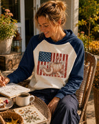 Woman wearing a navy cream sun hoodie with pumpkins and an American flag outdoors.