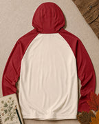 Back view of the women's sun hoodie with a plain cream body, red hood and long raglan sleeves.