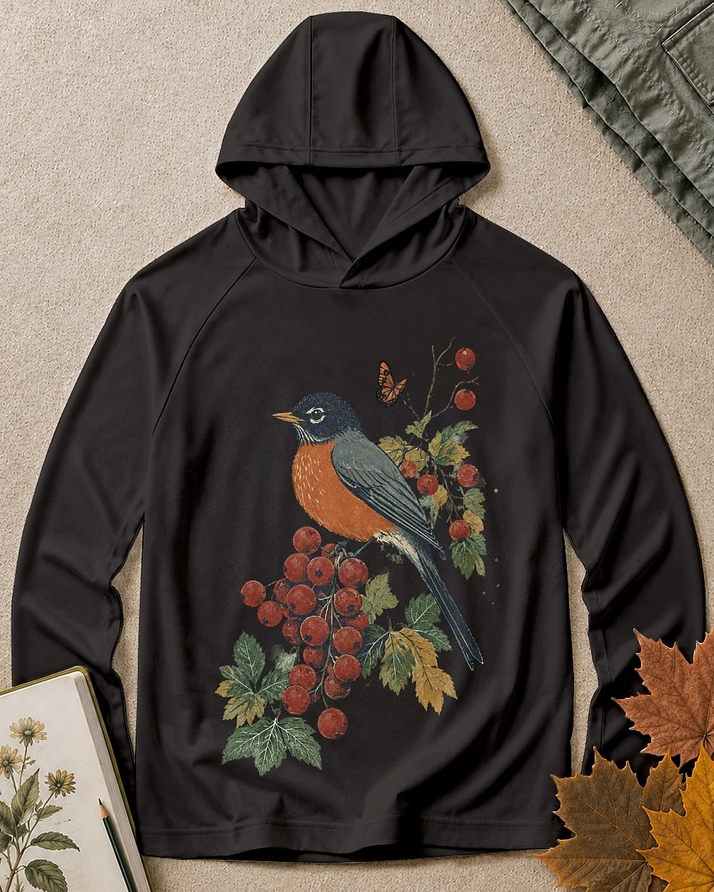 Women's black sun hoodie with a robin perched on a red berry branch, front view.