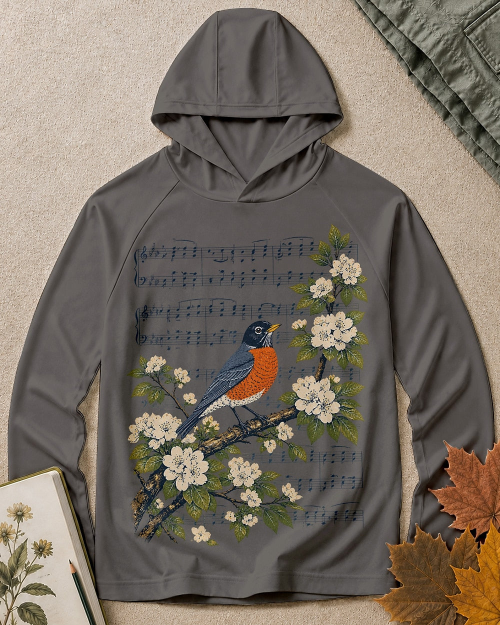 Women's dark gray sun hoodie with a robin, blossoms and musical notes, front view.
