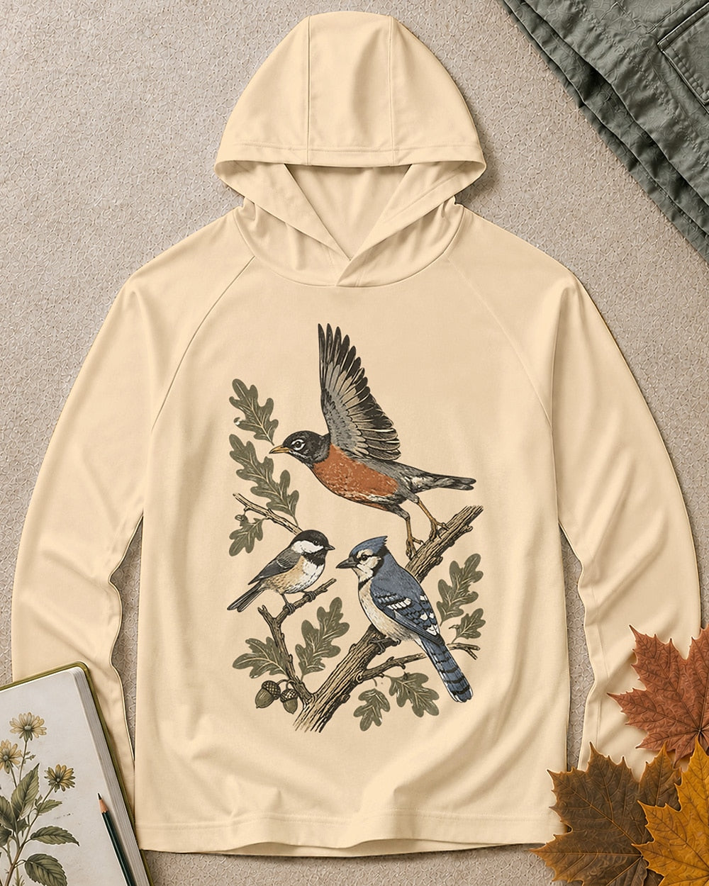 Women's light yellow sun hoodie with a flying robin and blue jay among branches, front view.