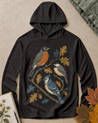 Women's black sun hoodie with a robin and blue jay among oak leaves, front view.