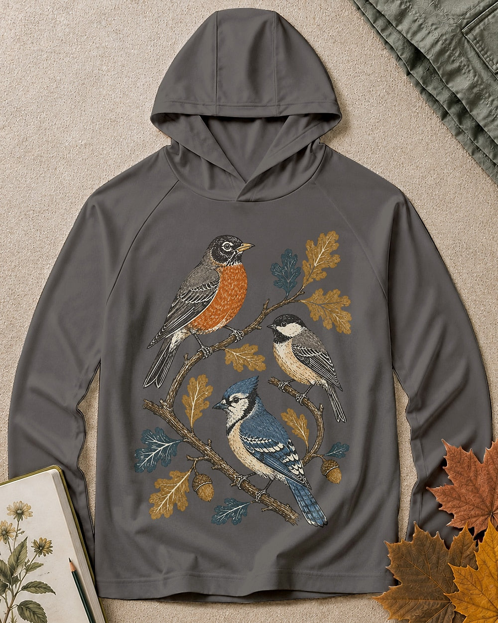 Women's dark gray sun hoodie with a robin and blue jay among oak leaves, front view.