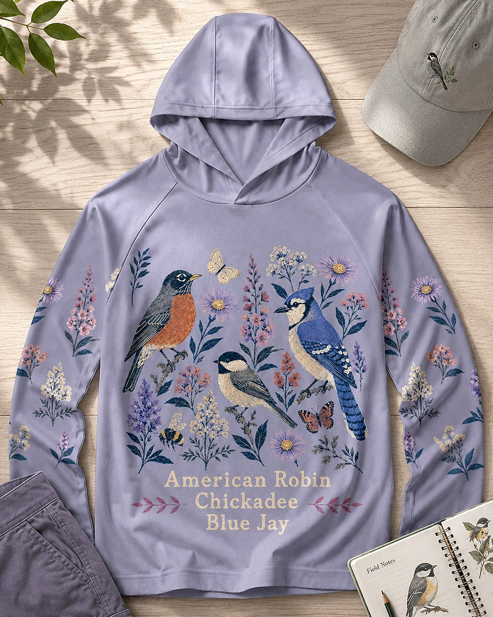 Women's violet sun hoodie with robins, chickadees, blue jays and wildflowers, front view.