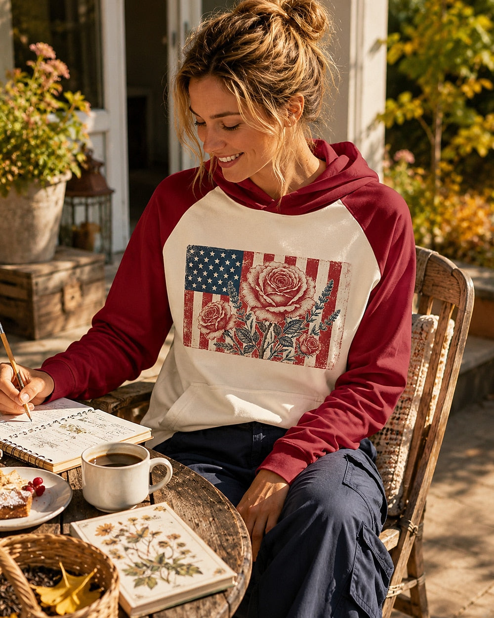 Woman wearing a red cream sun hoodie with roses and an American flag outdoors.