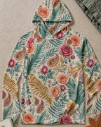 Women's green sun hoodie with an all-over rose and paisley pattern, front view.