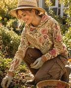 Woman wearing a yellow sun hoodie with an all-over rose and paisley pattern outdoors.