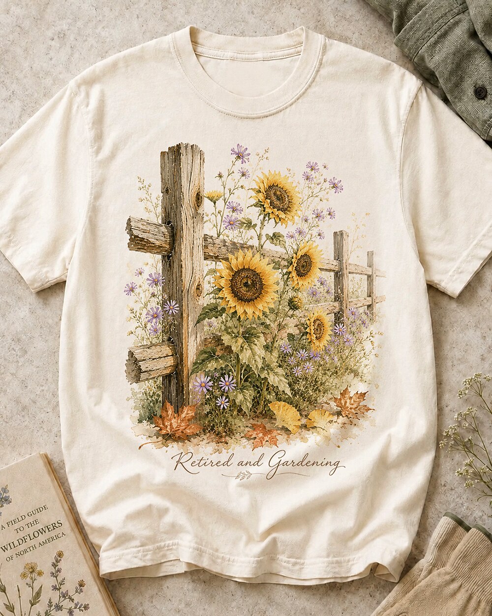 Women's off white cotton T-shirt with sunflowers beside a rustic wooden fence, front view.