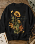 Women's black crewneck sweatshirt with vintage sunflowers and autumn leaves, front view.