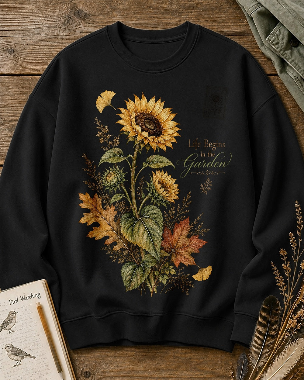 Women's black crewneck sweatshirt with vintage sunflowers and autumn leaves, front view.
