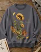 Women's gray crewneck sweatshirt with vintage sunflowers and autumn leaves, front view.